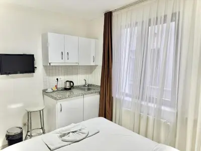 a bedroom with a bed and a sink and a window at Taksim Seven Residence in Istanbul