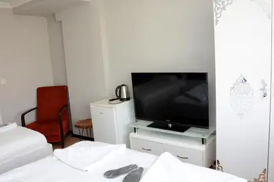 a bedroom with a flat screen tv and a bed at palmiye suıt otel in Istanbul