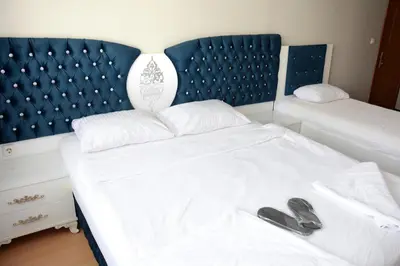 a bedroom with a white bed with a blue headboard at palmiye suıt otel in Istanbul