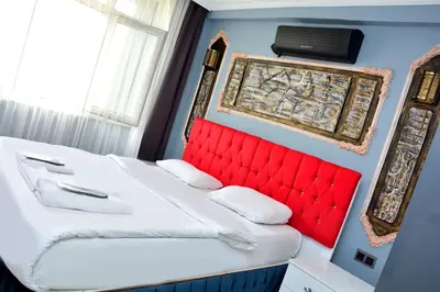 a bedroom with two beds and a red headboard at palmiye suıt otel in Istanbul