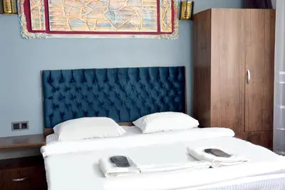 a bedroom with a large bed with a blue headboard at palmiye suıt otel in Istanbul