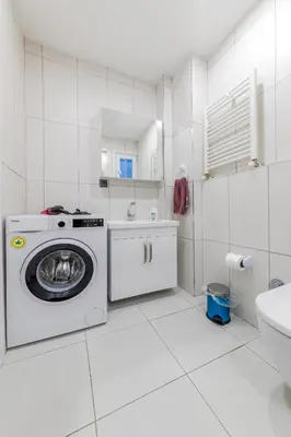 a white bathroom with a washing machine and a sink at Algold in Istanbul