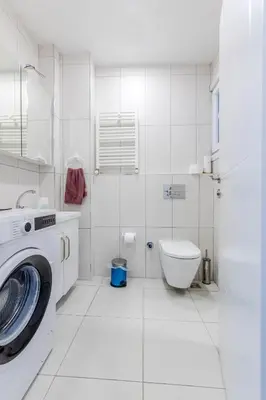 a white bathroom with a washing machine and a toilet at Algold in Istanbul