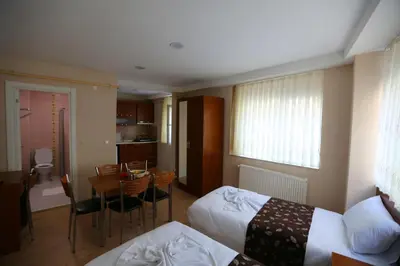 a hotel room with two beds and a table and a kitchen at Istanbul Family Apartment in Istanbul