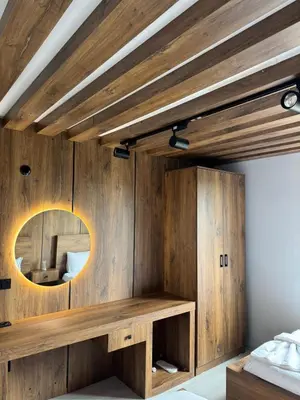 a bedroom with a wooden wall with a mirror at Lina Apart in Arnavutköy