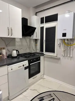 a white kitchen with a stove and white cabinets at ZARA'S HOME in Istanbul in Istanbul