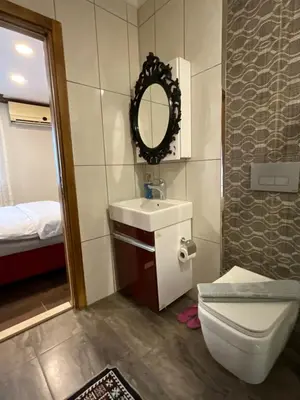 a bathroom with a toilet and a sink and a mirror at KAMER Apart Hotel in Istanbul