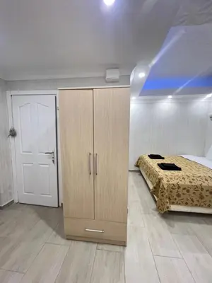 a bedroom with a bed and a wooden cabinet at KAMER Apart Hotel in Istanbul