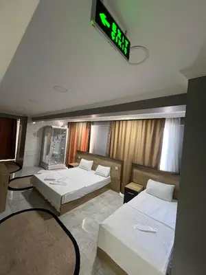 a room with two beds and a clock on the ceiling at The walens hotel in Istanbul