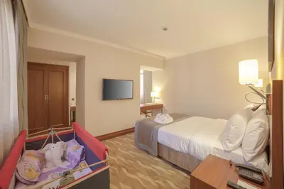 a hotel room with a bed and a baby crib at Lamec Hotel Business in Gebze