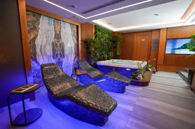 a room with a tub and chairs and a tv at Vital Hotel Suites in Istanbul