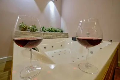 two glasses of wine sitting on a counter with a bath tub at Private Apartment at Beylikdüzü nearly to E5 2 in Beylikduzu