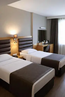 a hotel room with two beds and a desk at Riva Hotel Taksim in Istanbul