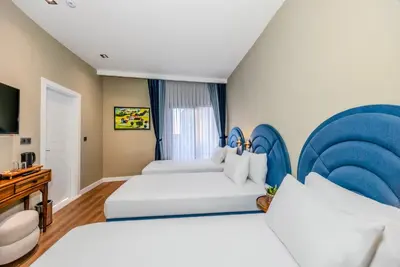 a hotel room with two beds and a television at Nenessa Airport Hotel in Arnavutköy