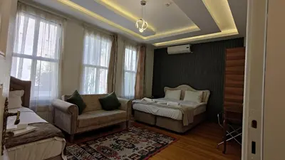 a living room with a bed and a couch and windows at Nuray Hotel in Istanbul