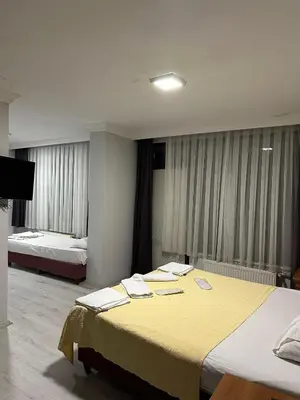 a hotel room with two beds and a flat screen tv at Brave otel in Darıca