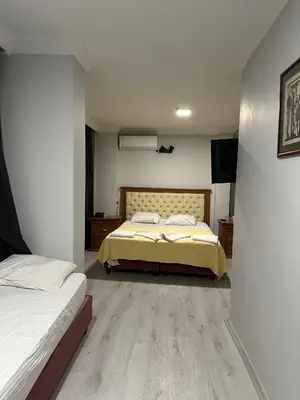 a bedroom with two beds and a television in it at Brave otel in Darıca