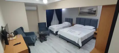 a hotel room with two beds and a desk and chairs at Lantis Otel in Avcılar