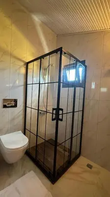 a bathroom with a toilet and a glass shower at Çınar home in Sapanca