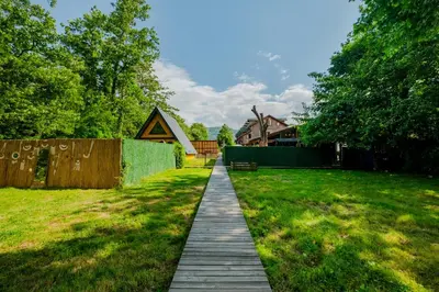 a wooden path through a yard with a fence at Meca Deluxe Otel Sapanca in Sapanca