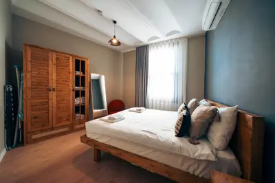 a bedroom with a bed with white sheets and a window at Galata Guest Teori in Istanbul