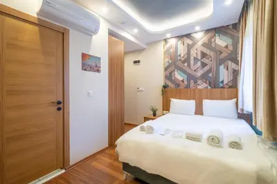 a bedroom with a large white bed with a wooden headboard at İstanbulites Hotel in Istanbul