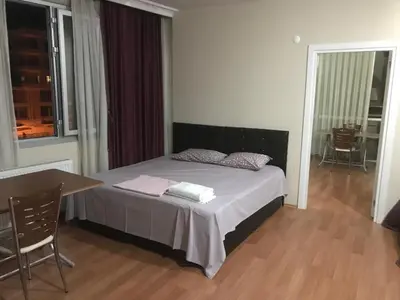a bedroom with a bed and a table and a window at Peri Pansiyon Butik Otel in Çınarcık