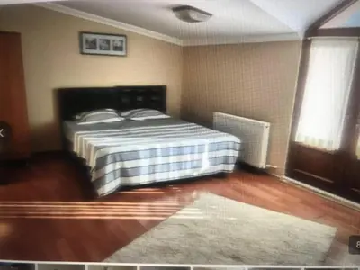 a bedroom with a bed in a room with wooden floors at Peri Pansiyon Butik Otel in Çınarcık