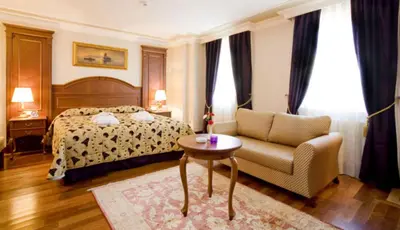 a bedroom with a bed and a chair and a table at GLK PREMIER Regency Suites & Spa in Istanbul