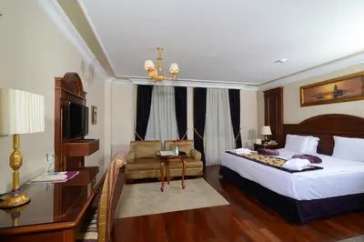 a hotel room with a bed and a chair at GLK PREMIER Regency Suites & Spa in Istanbul