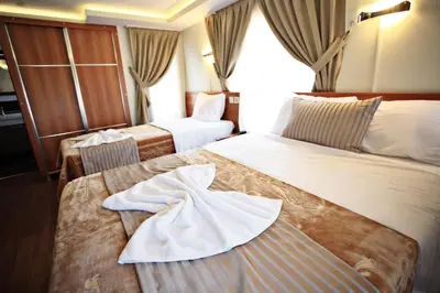 a hotel room with two beds and a towel on the bed at Taksim Palace Hotel in Istanbul