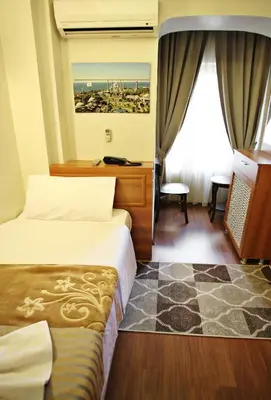 a hotel room with two beds and a window at Taksim Palace Hotel in Istanbul