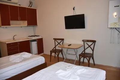 a room with two beds and a table and a kitchen at Taksim Palace Hotel in Istanbul