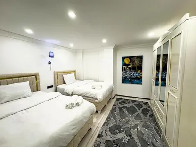 a bedroom with two beds and a painting on the wall at Sisli Holiday 231 in Istanbul