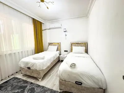 two beds in a room with white walls at Sisli Holiday 231 in Istanbul