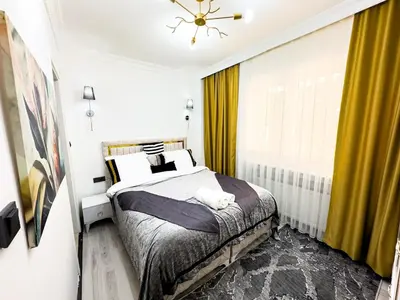 a bedroom with a bed and a window with yellow curtains at Sisli Holiday 231 in Istanbul