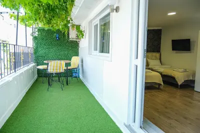 a small balcony with a table and chairs and a room at Taksim Neo Pera Suites in Istanbul