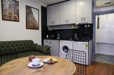 a kitchen and living room with a table and a couch at Taksim Neo Pera Suites in Istanbul