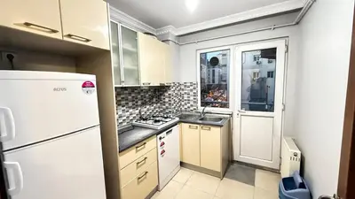 a small kitchen with a refrigerator and a window at Bomenti Sisli in Istanbul