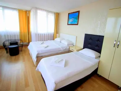 a hotel room with two beds with white sheets at SİMGE SULTAN' old cty in Istanbul