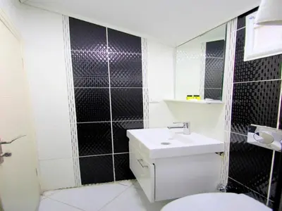 a bathroom with a toilet and a sink and a mirror at SİMGE SULTAN' old cty in Istanbul