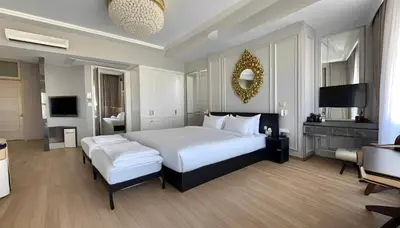 a bedroom with a large white bed and a television at SİMGE SULTAN' old cty in Istanbul