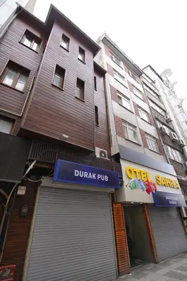 a building with a blue sign in front of a garage at Sahra Otel in Istanbul