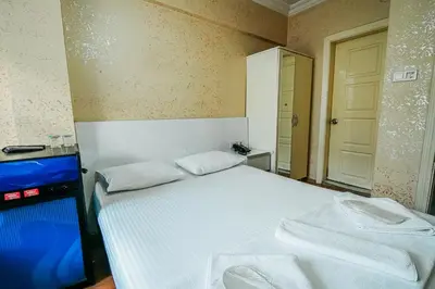 a bedroom with a white bed and a tv at Sahra Otel in Istanbul