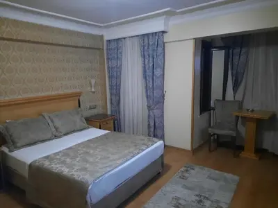 a bedroom with a bed and a chair and a window at GRAND HiSAR HOTEL in Istanbul