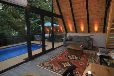 a living room with a couch and a pool at Köyevi Teras Bungolov in Kartepe