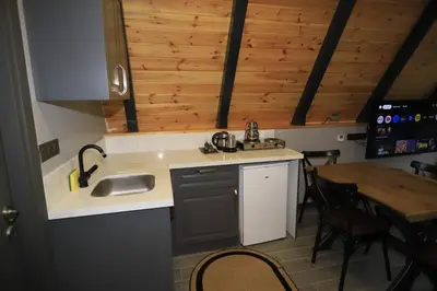 a kitchen with a sink and a table with chairs at Köyevi Teras Bungolov in Kartepe