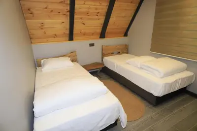 two beds in a room with wooden ceilings at Köyevi Teras Bungolov in Kartepe