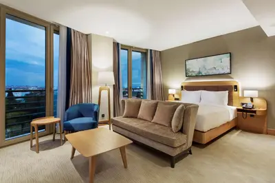 a hotel room with a bed and a couch and window at DoubleTree by Hilton Hotel Istanbul - Tuzla in Istanbul