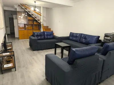 a living room with blue couches and a staircase at Villa Taskoparan in Tekirdag